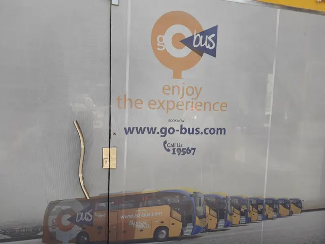 The image shows a bus parked in front of a building with a sign that reads "Enjoy the Experience"....