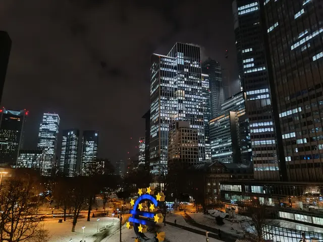 The image shows the European Central Bank (ECB) headquarters in Frankfurt, Germany at night. We can...