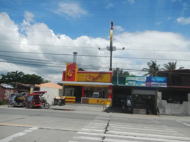 The image shows a street scene with a gas station in the middle of it, surrounded by buildings,...