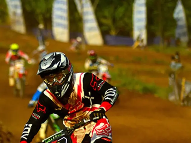 This picture looks like motorbike race. We see few people riding bikes and they wore helmets on...