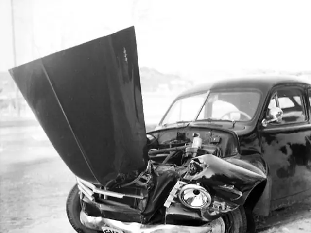 The image shows a black and white photo of a car that has been involved in a crash on the side of...