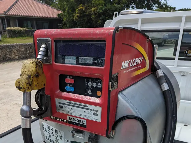 The image shows a truck with a gas pump in the back of it, surrounded by trees, a house, and a...