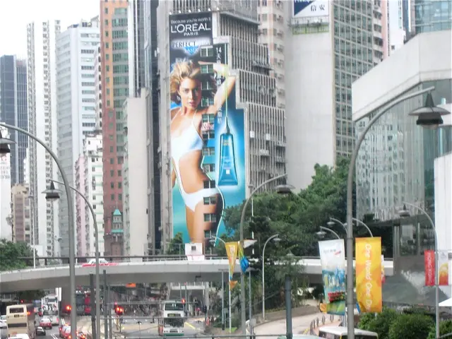 The image shows a bustling city street filled with lots of traffic, including double decker buses,...