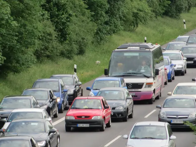 The image shows a traffic jam on a highway with many cars and a van. There are people in the...