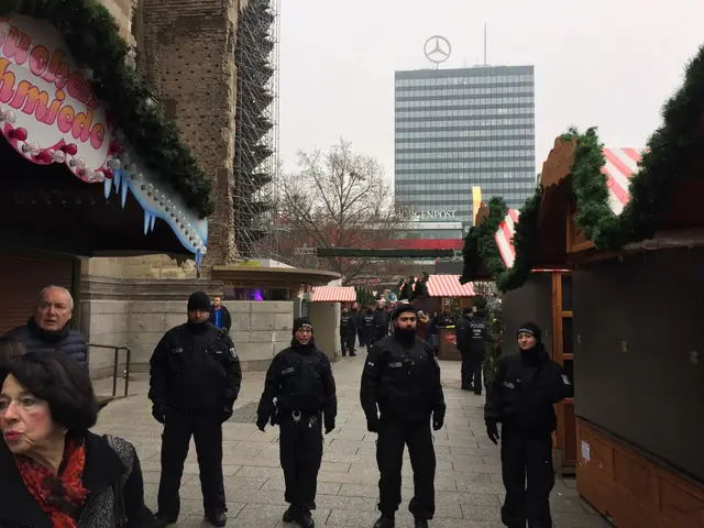 The image shows a group of police officers standing in front of a Christmas market in Berlin,...