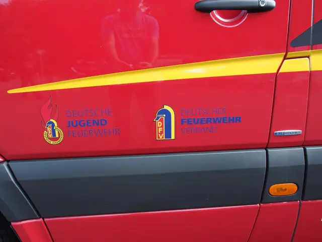 The image shows a red van with a yellow stripe on the side of it, a door handle, and a logo and...