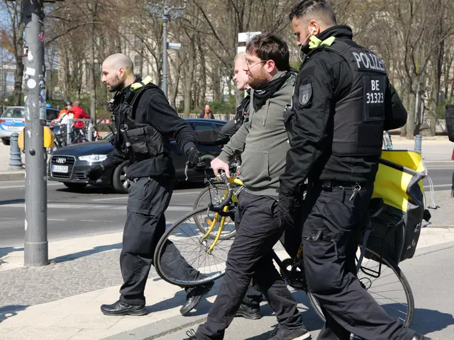 The image shows three police officers walking down the street with their bicycles, surrounded by a...