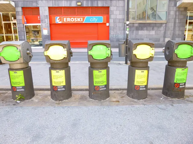 The image shows a row of parking meters sitting on the side of a street, with a building in the...