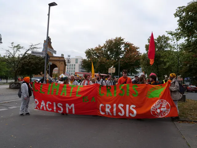 The image shows a group of people walking down a street, holding a banner that reads "Climate...