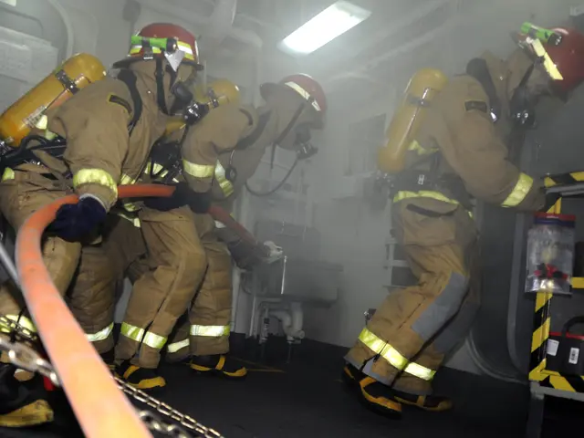 The image shows a group of firefighters in protective gear, wearing helmets and oxygen cylinders,...