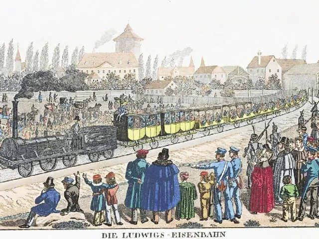 The image shows a group of people standing around a train on a track, with a few people sitting in...