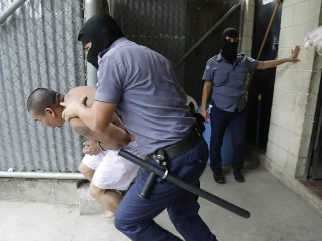 The image shows a man being escorted by two police officers in front of a building. The man is...