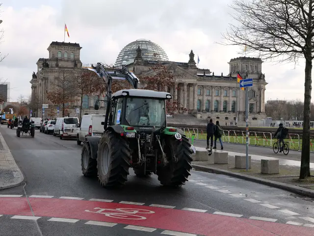 The image shows a tractor driving down a street in front of the Reichstag building in Berlin,...