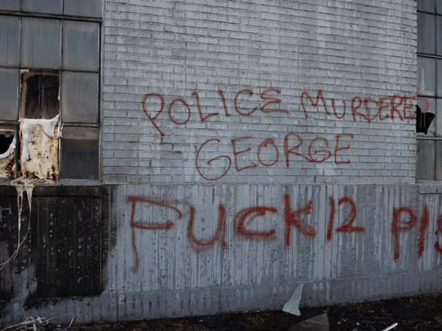 The image shows a building with graffiti on the side of it that reads "Police Murder George Fuck 12...