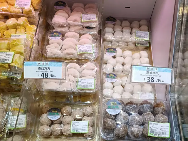 The image shows a display case filled with lots of different types of food in plastic boxes, each...