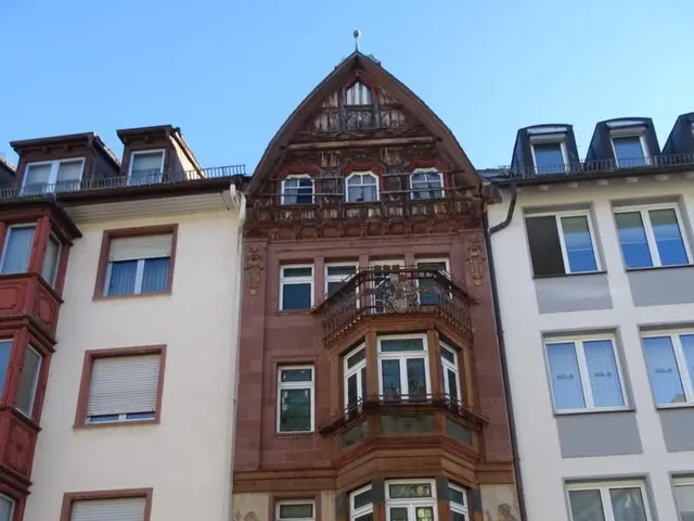 The image shows a building with many windows on the side of it, situated on a road with a clear...