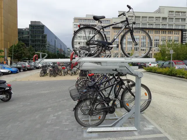 The image shows a parking lot with several bicycles parked on top of a metal rack. There are also...
