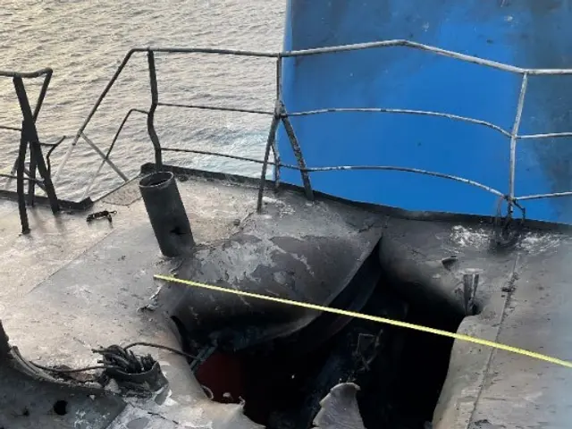 The image shows a boat with a hole in the side of it, surrounded by water. On the right side of the...