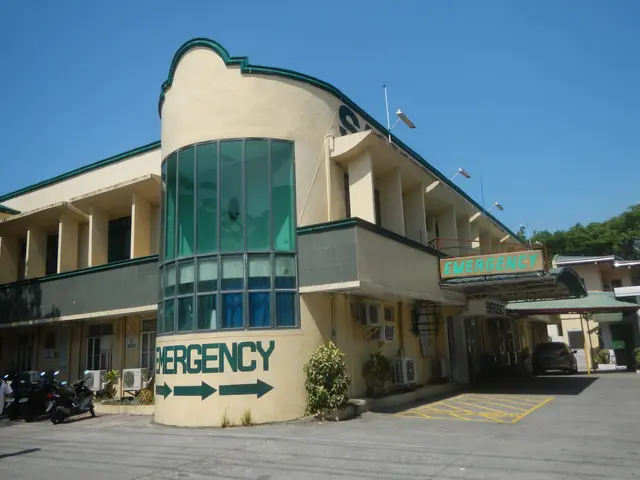 The image shows a building with a sign that reads "Emergency" on the side of it, surrounded by...