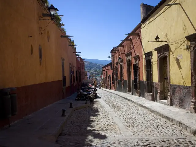 In this image there is a empty road where so many bikes are parked, beside that there are so many...