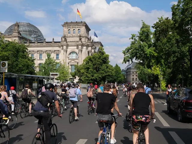 The image shows a group of people riding bicycles down a street in Berlin, Germany. The street is...