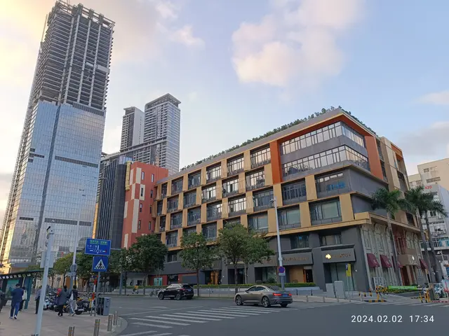 The image shows a bustling city street with tall buildings in the background. There are vehicles on...