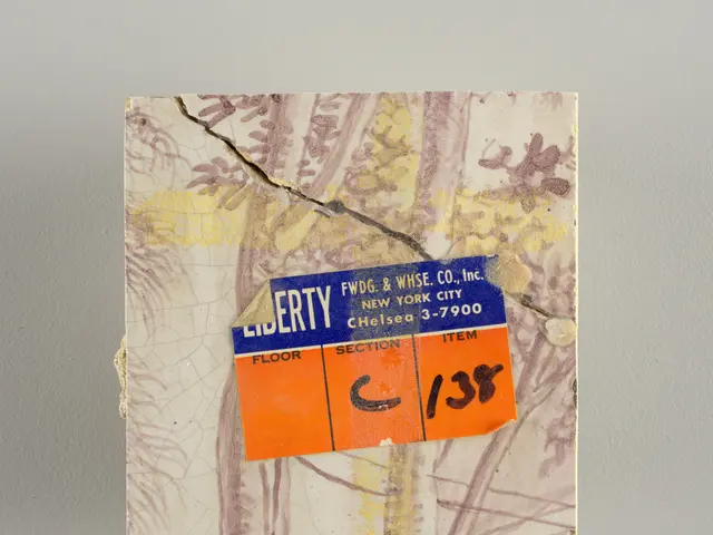 The image shows a piece of paper attached to a wall with a label on it. The label has text written...