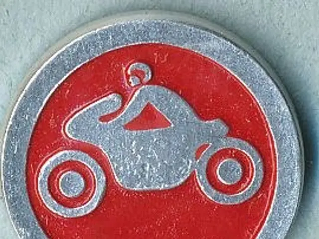 The image shows a red and silver sign with a person riding a motorcycle on it. The sign is round in...