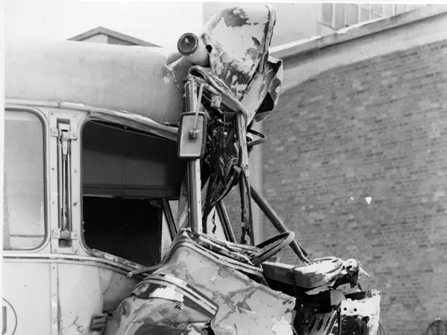 The image shows a black and white photo of a bus that has been involved in a crash, with its front...