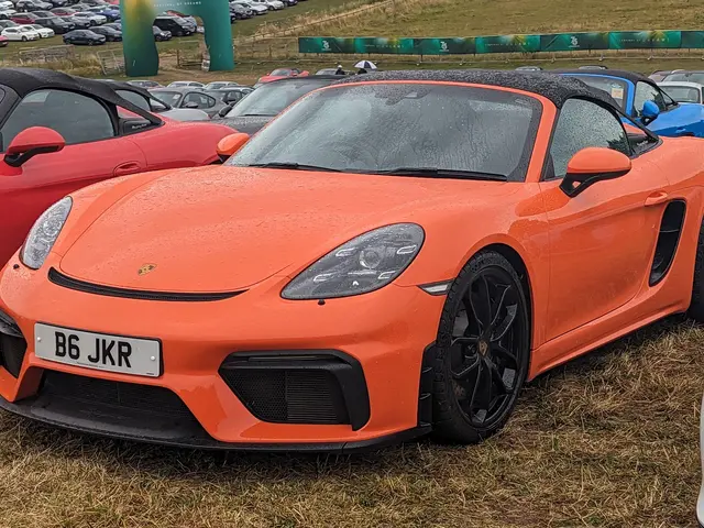 The image shows a Porsche 718 Boxster GTS at the Goodwood Festival of Speed. There are cars on the...