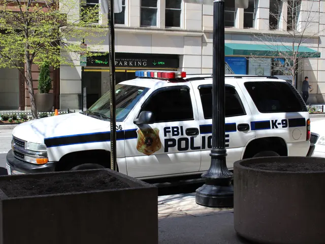The image shows a police car parked on the side of a street, surrounded by buildings with windows,...